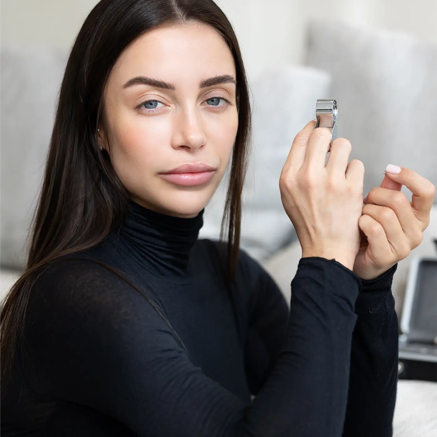 La fondatrice contrôle la qualité d'un piercing dans une loupe