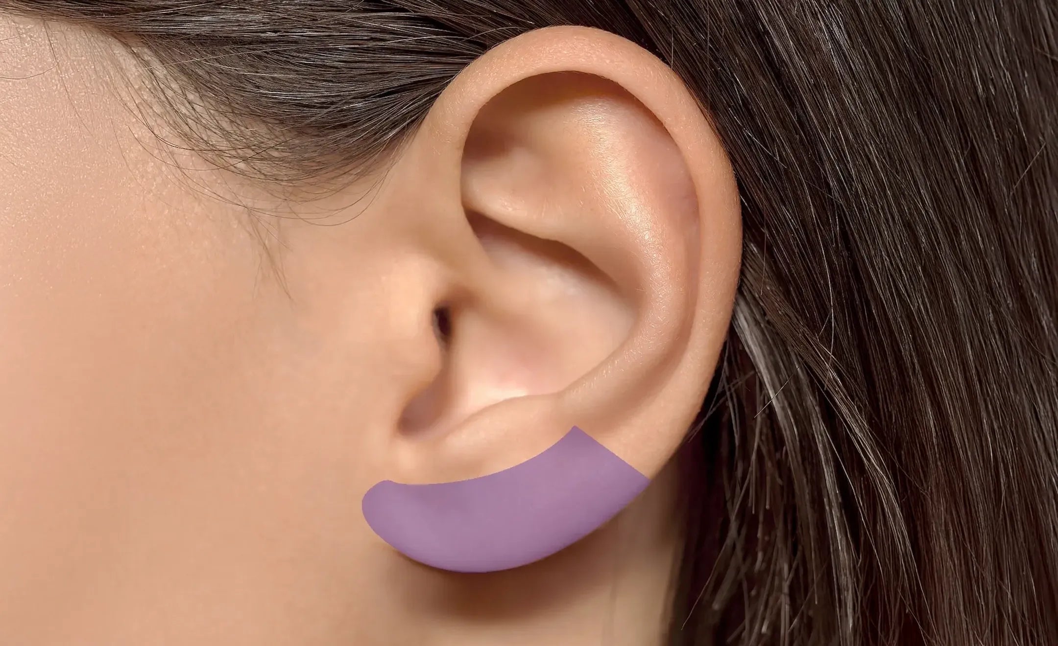 Close-up of a human ear with a purple curved overlay highlighting the lobe part of the ear
