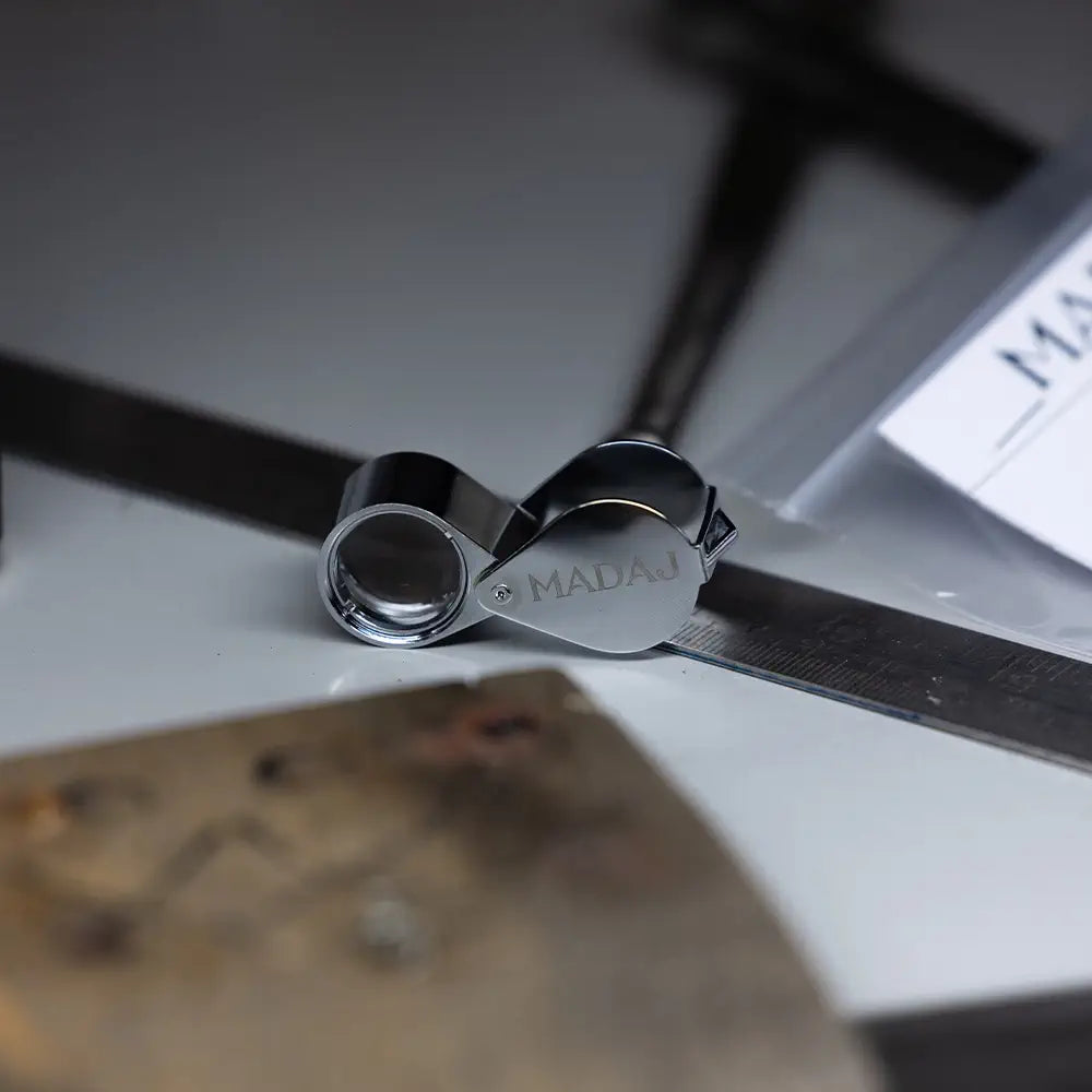 Loupe MADAJ posée sur un établi de bijoutier