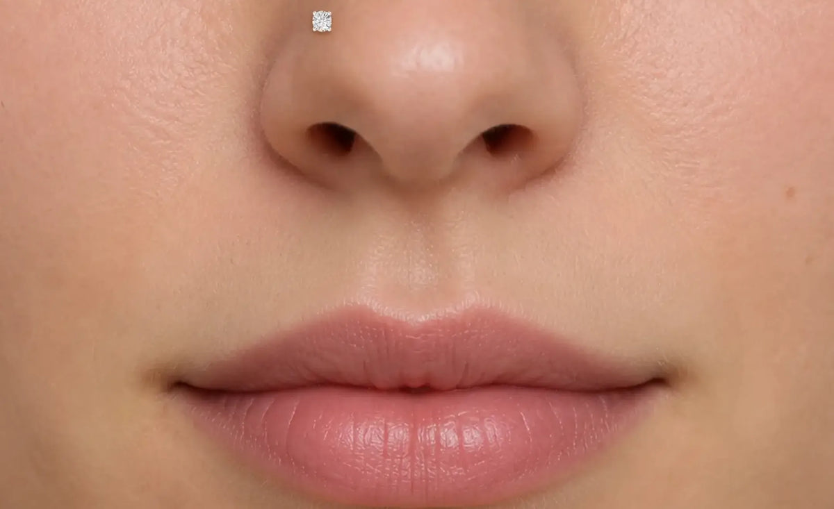 Gros plan extrême du nez et des lèvres d'une personne, montrant un piercing nostril stud diamant rond sur le côté gauche du nez
