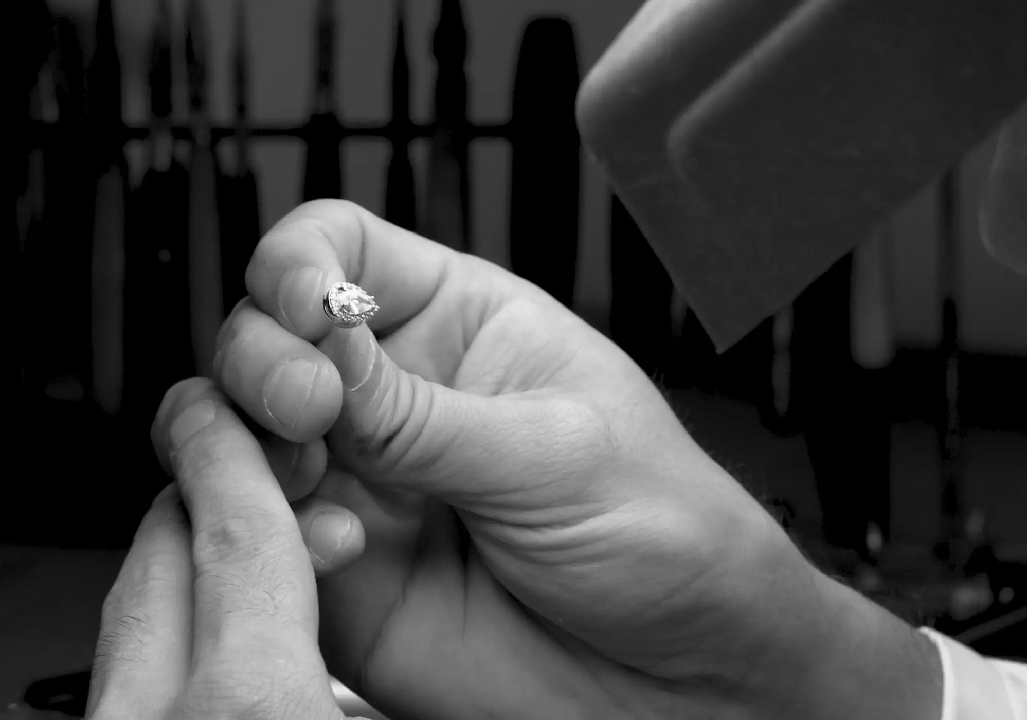 Un artisan examine à la loupe un bijou.